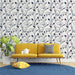 Un salon moderne avec un papier peint floral bleu marine et blanc représentant des fleurs délicates, créant une atmosphère élégante et apaisante.