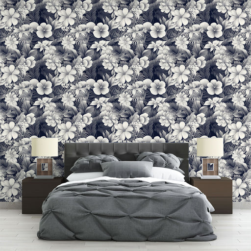 Une chambre moderne avec un papier peint floral bleu marine et blanc, évoquant une atmosphère tropicale et apaisante grâce à ses motifs de fleurs et de feuillages.
