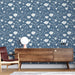 Une pièce moderne avec un papier peint floral bleu nuit orné de motifs blancs délicats, créant une ambiance douce et apaisante.