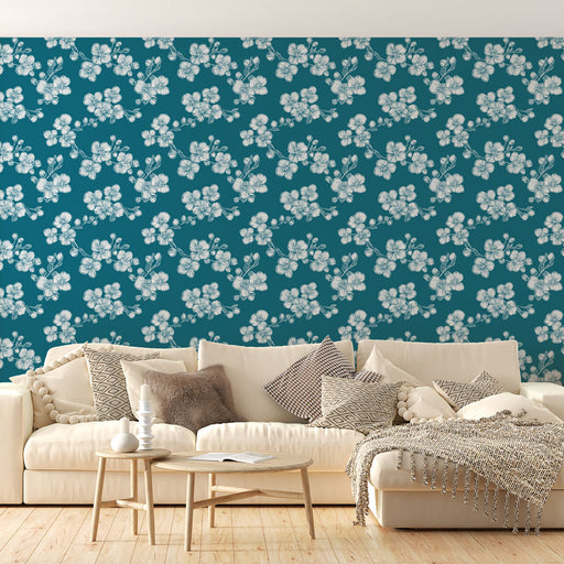 Un salon lumineux avec un papier peint floral bleu canard et blanc, évoquant une ambiance fraîche et apaisante grâce à ses motifs délicats.