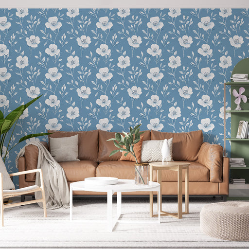Un salon lumineux avec un papier peint floral bleu clair orné de grandes fleurs blanches, créant une ambiance douce et accueillante.