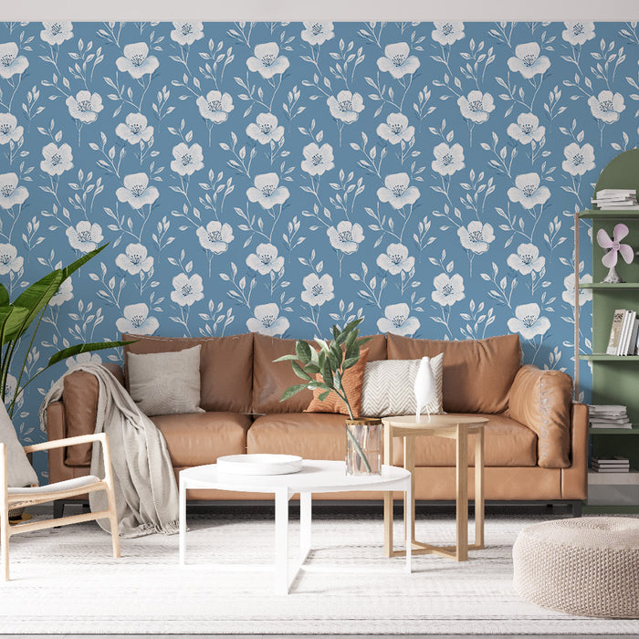 Un salon lumineux avec un papier peint floral bleu clair orné de grandes fleurs blanches, créant une ambiance douce et accueillante.