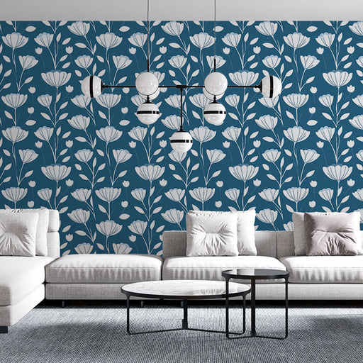 Un salon moderne avec un papier peint floral bleu profond aux motifs blancs délicats, créant une atmosphère élégante et apaisante.