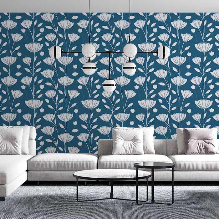 Un salon moderne avec un papier peint floral bleu profond aux motifs blancs délicats, créant une atmosphère élégante et apaisante.