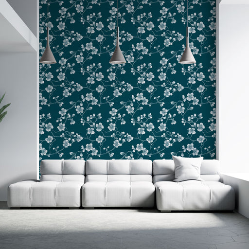 Un salon moderne avec un papier peint floral bleu canard orné de délicates fleurs blanches, créant une atmosphère élégante et apaisante.