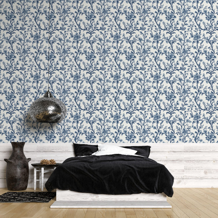 Une chambre moderne avec un papier peint floral bleu sur fond clair, créant une atmosphère élégante et apaisante.