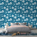 Une chambre moderne avec un papier peint floral bleu profond orné de grandes fleurs blanches et bleues, créant une ambiance fraîche et apaisante.