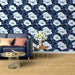 Un salon moderne avec un papier peint floral bleu marine et blanc, aux grandes fleurs délicates, créant une ambiance fraîche et accueillante.