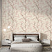 Une chambre moderne avec un papier peint floral aux motifs de branches délicates et fleurs roses sur fond crème, créant une atmosphère douce et apaisante.