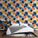 Une chambre moderne avec un papier peint floral aux teintes vives d'orange, bleu et blanc, créant une ambiance tropicale et vivifiante.