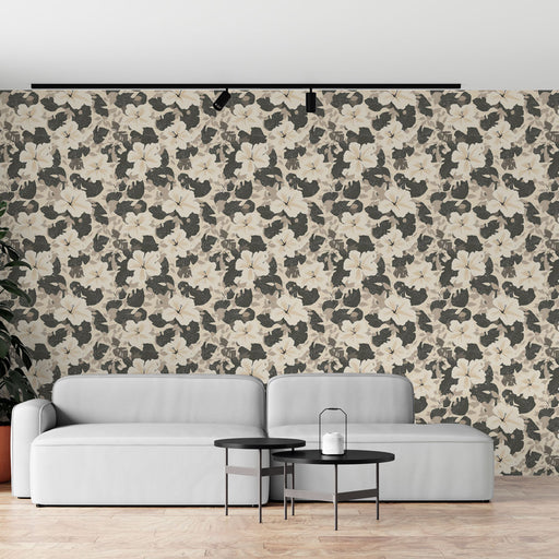 Un salon moderne avec un papier peint floral aux teintes beige et gris, présentant de grandes fleurs blanches sur un fond texturé, créant une atmosphère élégante et apaisante.