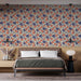 Une chambre élégante avec un papier peint floral aux motifs colorés d'orange et de bleu sur fond clair, créant une atmosphère chaleureuse et accueillante.