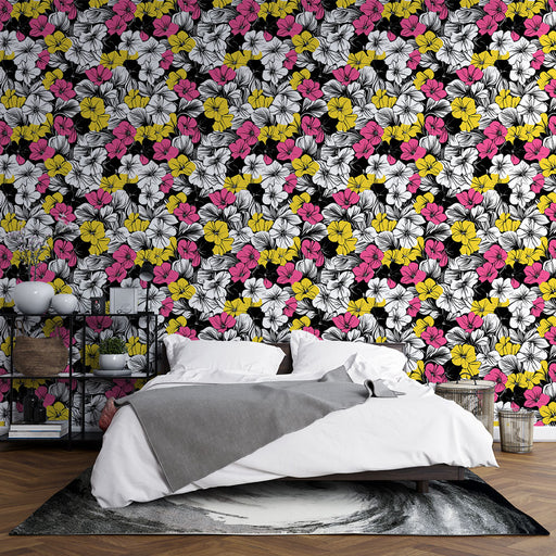 Une chambre moderne avec un papier peint floral éclatant aux motifs de fleurs blanches, roses et jaunes sur fond noir, créant une ambiance vivante et dynamique.