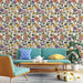 Une pièce de vie lumineuse avec un papier peint floral aux motifs colorés sur fond clair, créant une ambiance joyeuse et accueillante.