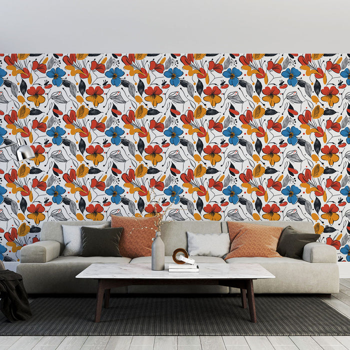 Un salon moderne avec un papier peint floral aux motifs colorés rouges, bleus et noirs sur fond blanc, créant une ambiance joyeuse et dynamique.