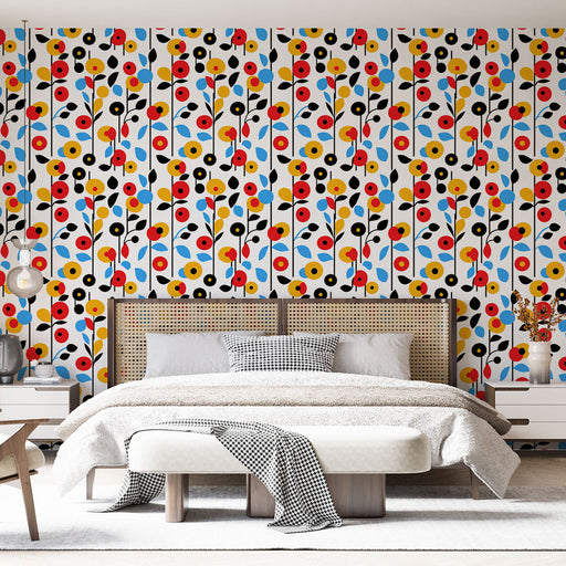 Une chambre moderne avec un papier peint floral aux motifs colorés de fleurs rouges, jaunes, noires et bleues sur fond blanc, créant une ambiance joyeuse et dynamique.