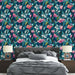 Une chambre élégante avec un papier peint floral aux teintes vibrantes de rose et de vert sur un fond bleu, créant une atmosphère vivante et accueillante.