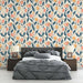 Une chambre moderne avec un papier peint floral aux motifs colorés de fleurs et de fruits sur fond clair, créant une ambiance fraîche et accueillante.