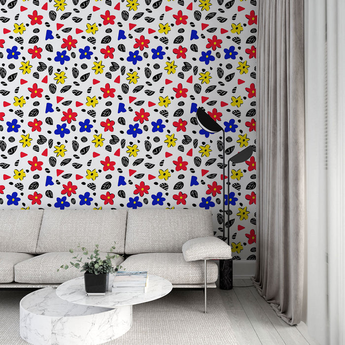 Un salon moderne avec un papier peint coloré aux motifs floraux et géométriques, mêlant rouge, bleu et jaune sur fond blanc, créant une ambiance joyeuse et dynamique.