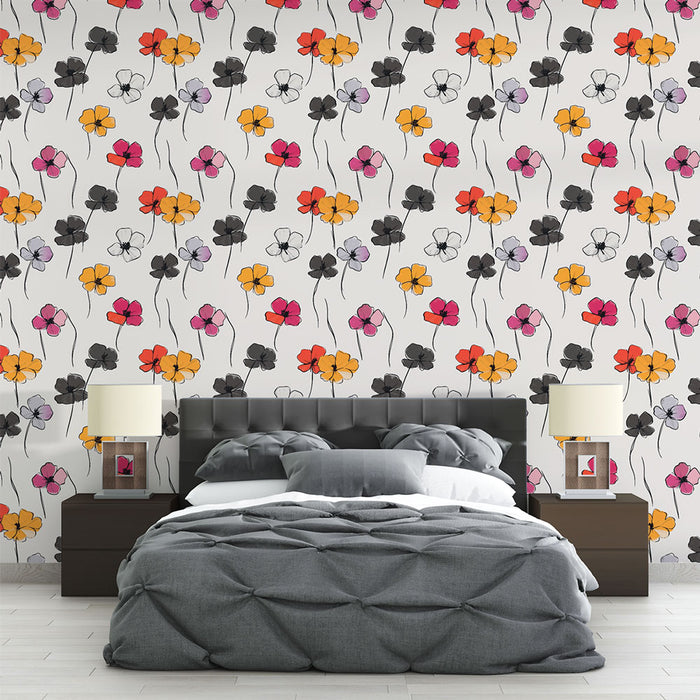 Une chambre moderne avec un papier peint floral coloré aux motifs de fleurs noires, jaunes, rouges et violettes sur fond blanc, créant une ambiance joyeuse et dynamique.