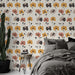 Une chambre moderne avec un papier peint floral aux teintes chaudes de jaune, rose et noir, créant une atmosphère accueillante et joyeuse.
