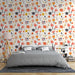 Une chambre accueillante avec un papier peint floral aux motifs colorés de fleurs roses, jaunes et bleues sur fond clair, créant une ambiance joyeuse et vivante.