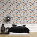 Une chambre moderne avec un papier peint floral aux motifs colorés de fleurs et feuillages sur fond clair, créant une atmosphère chaleureuse et accueillante.