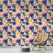 Une pièce moderne avec un papier peint tropical aux motifs colorés de fleurs roses, jaunes et feuilles vertes sur fond clair, créant une ambiance vivante et joyeuse.
