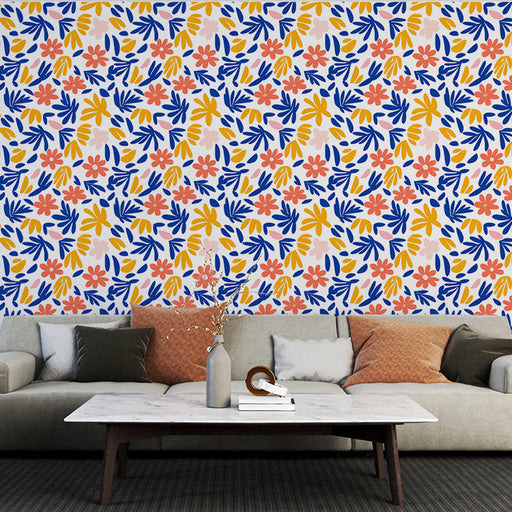 Un salon moderne avec un papier peint floral coloré aux motifs de fleurs et de feuillages dans des teintes vives de bleu, jaune et rose, créant une ambiance joyeuse et dynamique.