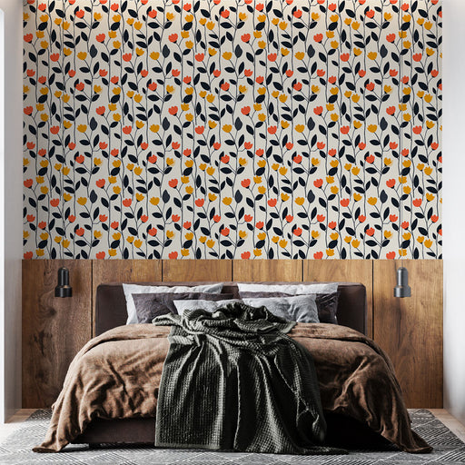 Une chambre moderne avec un papier peint floral aux motifs colorés de fleurs rouges, jaunes et noires sur fond clair, créant une ambiance joyeuse et accueillante.