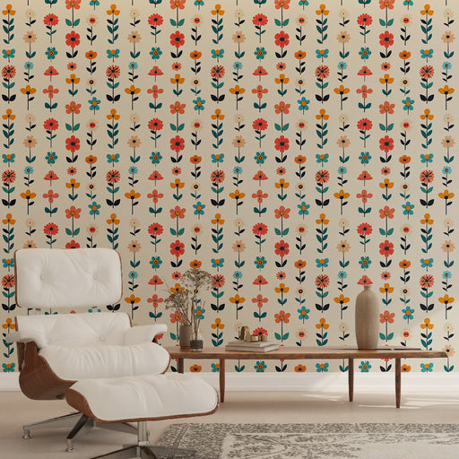 Un salon lumineux avec un papier peint floral aux motifs colorés de fleurs rouges, oranges et bleues sur fond crème, créant une ambiance joyeuse et accueillante.