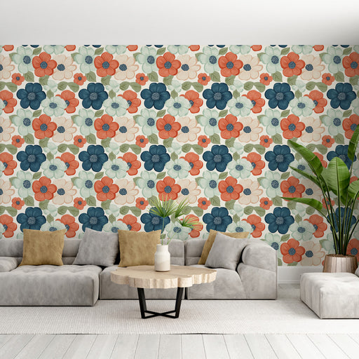 Un salon lumineux avec un papier peint floral aux motifs colorés de fleurs orange, bleues et blanches sur fond clair, créant une ambiance joyeuse et accueillante.
