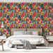 Une chambre lumineuse avec un papier peint floral aux motifs colorés de fleurs rouges, jaunes et bleues sur fond beige, créant une ambiance joyeuse et dynamique.