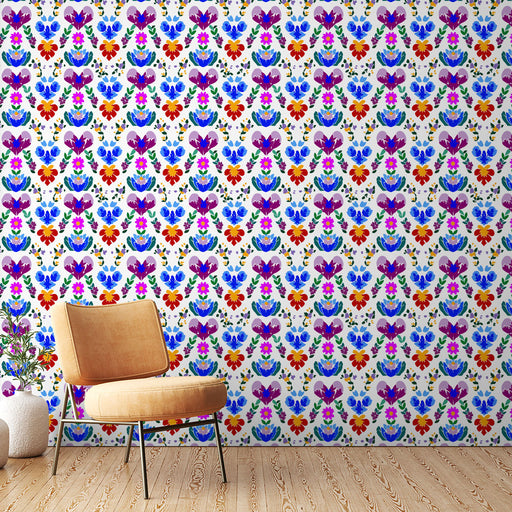 Une pièce lumineuse avec un papier peint floral coloré aux motifs vibrants de fleurs rouges, bleues et violettes sur fond clair, créant une ambiance joyeuse et accueillante.