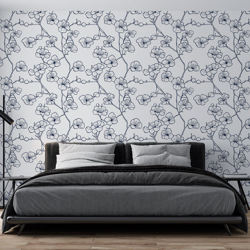 Une chambre moderne avec un papier peint floral bleu marine sur fond blanc, évoquant une ambiance douce et élégante.