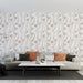 Un salon moderne avec un papier peint floral aux motifs délicats de fleurs beige et grises sur fond blanc, créant une ambiance douce et apaisante.