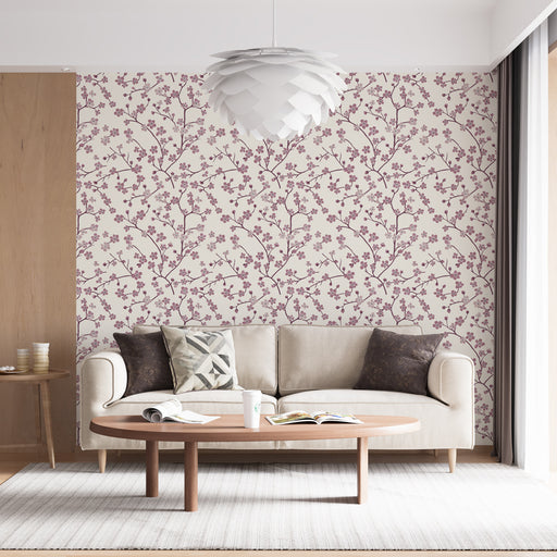 Un salon lumineux avec un papier peint floral aux motifs de branches délicates et fleurs mauves sur fond clair, créant une ambiance douce et accueillante.