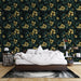 Une chambre accueillante avec un papier peint tropical noir orné de fleurs dorées et de feuillages luxuriants, créant une atmosphère chaleureuse et élégante.