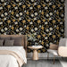 Une chambre élégante avec un papier peint floral noir orné de fleurs blanches et dorées, créant une atmosphère chic et chaleureuse.