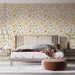 Une chambre moderne avec un papier peint floral aux teintes jaunes et grises, créant une ambiance chaleureuse et accueillante.