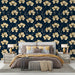 Une chambre élégante avec un papier peint floral doré sur fond bleu nuit, créant une atmosphère chaleureuse et sophistiquée.