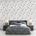 Une chambre moderne avec un papier peint floral aux motifs colorés de fleurs bleues et roses sur fond clair, créant une atmosphère douce et accueillante.