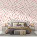 Une chambre élégante avec un papier peint floral aux motifs de fleurs délicates dans des teintes rose et beige, créant une atmosphère douce et romantique.