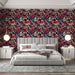 Une chambre élégante avec un papier peint floral aux motifs riches et colorés sur fond bleu marine, créant une atmosphère chaleureuse et accueillante.