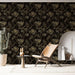 Une pièce moderne avec un papier peint floral noir aux motifs dorés et argentés, créant une ambiance élégante et sophistiquée.