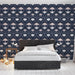 Une chambre moderne avec un papier peint floral bleu nuit et rose aux motifs élégants, créant une atmosphère chaleureuse et apaisante.