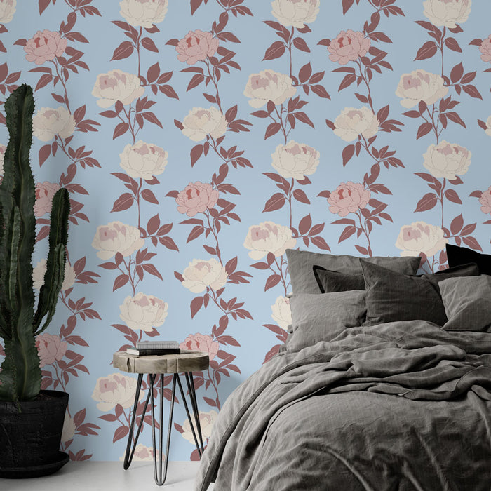Une chambre moderne avec un papier peint floral aux roses blanches et roses sur fond bleu, créant une atmosphère douce et apaisante.