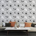 Un salon moderne avec un papier peint floral noir et blanc représentant de grandes fleurs délicates, créant une ambiance élégante et artistique.