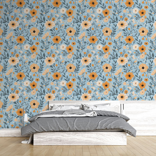 Une chambre lumineuse avec un papier peint floral bleu clair orné de grandes fleurs blanches et orange, créant une atmosphère fraîche et accueillante.