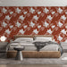 Une chambre moderne avec un papier peint floral aux motifs de fleurs blanches et terracotta sur fond rouge, créant une ambiance chaleureuse et accueillante.